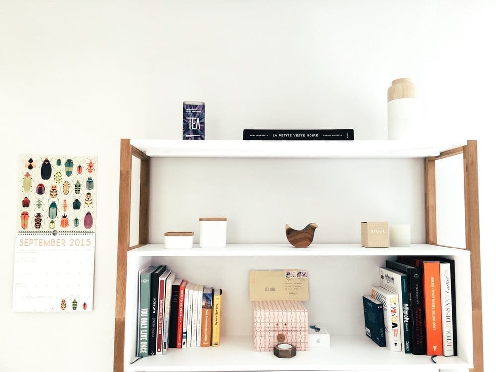 Three-tier vertical storage shelf with books and items